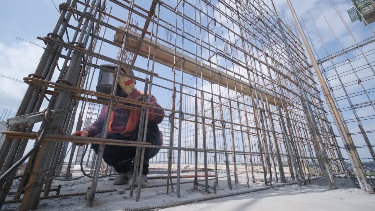 trabajador de la construcción que soldaba barras de refuerzo metálicas para el vertido de estructuras monolíticas