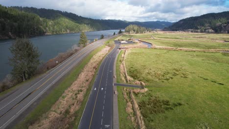 hermosa toma aérea de 4k que muestra el paso por la autopista al lado de dean creek en reedsport, oregon
