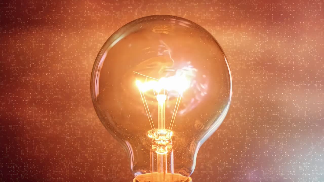 Video in primo piano di una lampadina luminosa su uno sfondo viola, girato all'altezza degli occhi