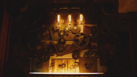 camera moving on wall decorated with mechanism of metallic gears and loft style lamps . interior with industrial  style design . close-up slow motion . flashing lights .