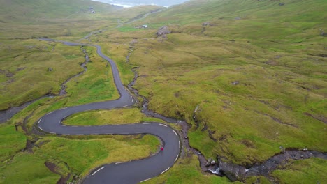 Elevación-Aérea-Revela-Una-Carretera-Sinuosa-En-El-Paso-De-Montaña-En-Streymoy,-Islas-Feroe.