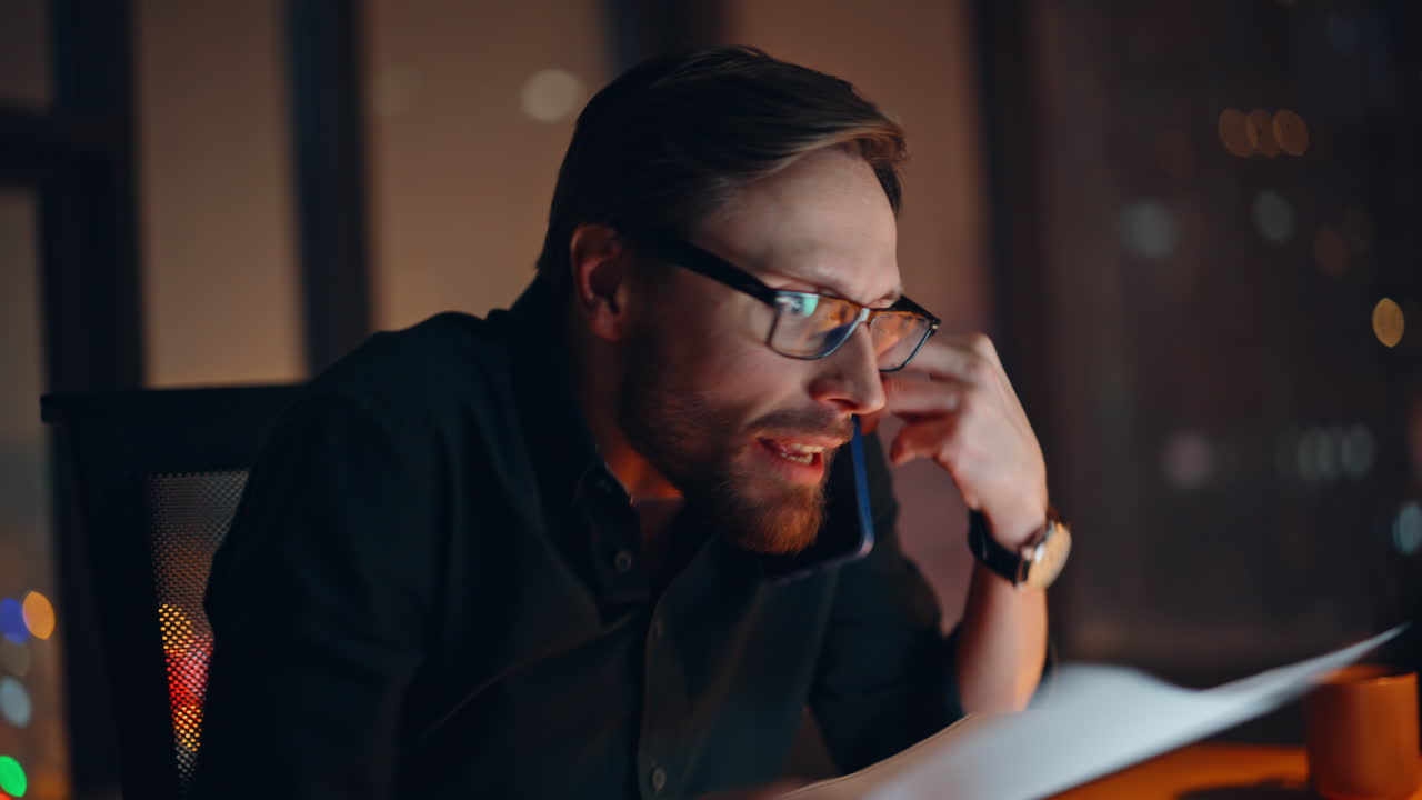 Concerned businessman yelling mobile phone in night office closeup. Angry man