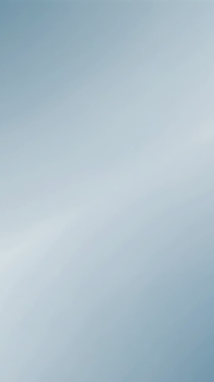 Vertical video: Pale blue sky with thin cirrus streaks drifting from high wind, weather for design