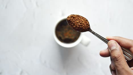 slow motion of dropping coffee power in a coffee cup