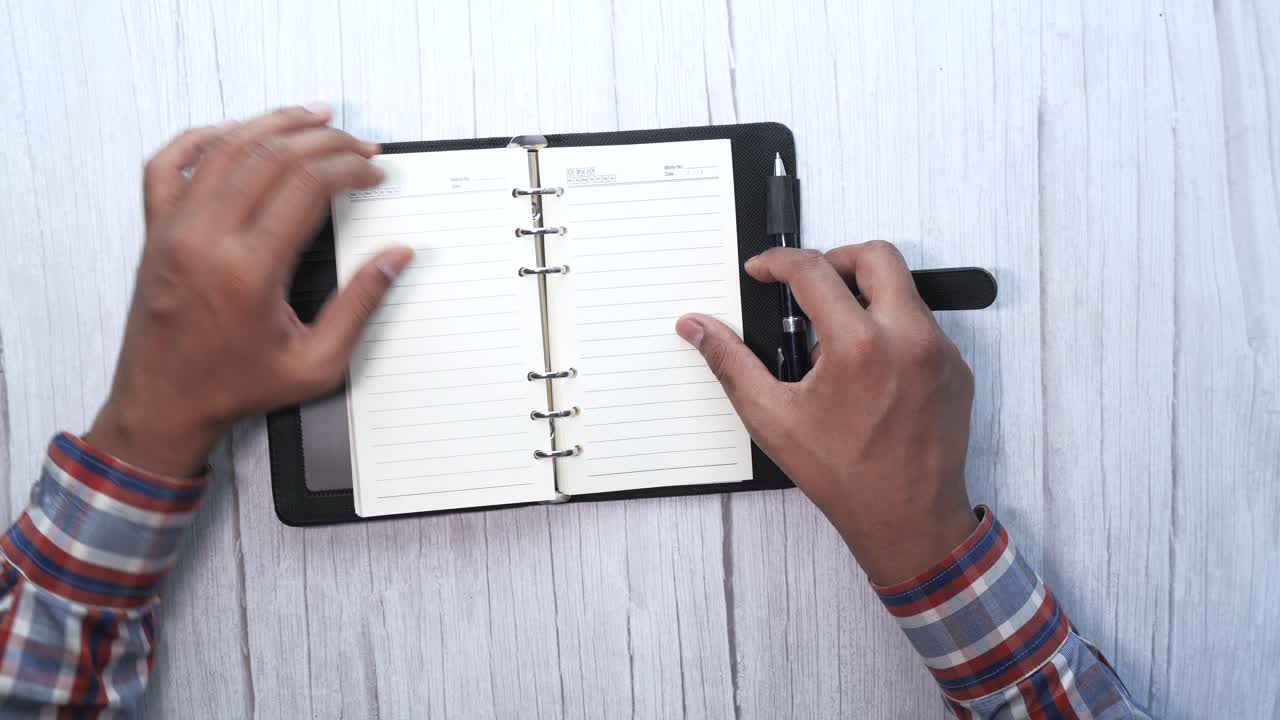 Person Using a Notebook and Pen