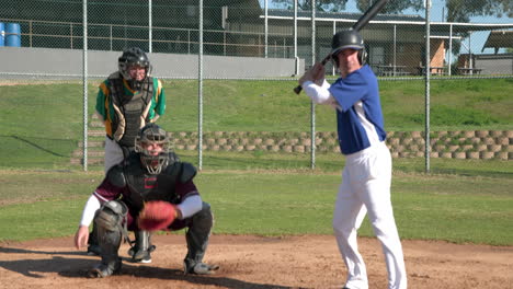 playing baseball, batter in blue uniform preparing to hit with catcher and umpire watching