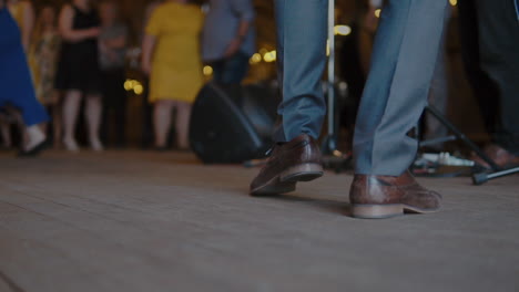 foot of a male artist stomping on the floor while performing in front of the audience - slow motion