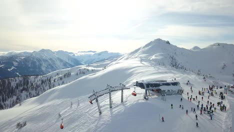 Aerial-Drone-view-of-a-Ski-Lift-on-top-of-a-snowy-mountain-with-people-on-Wintersport-Flachau,-Austria