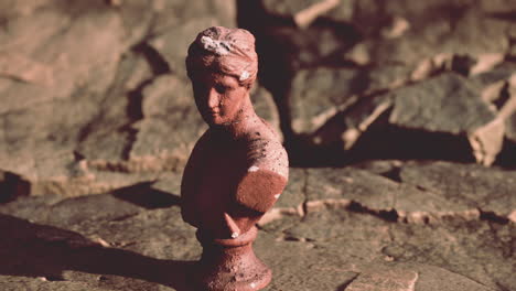 ancient statue of woman on rocky stones