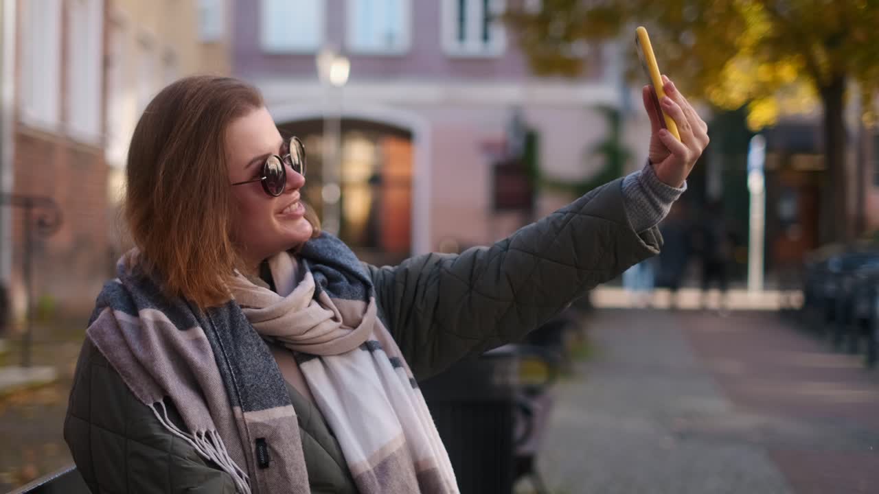 Woman taking a selfie in the city during autumn