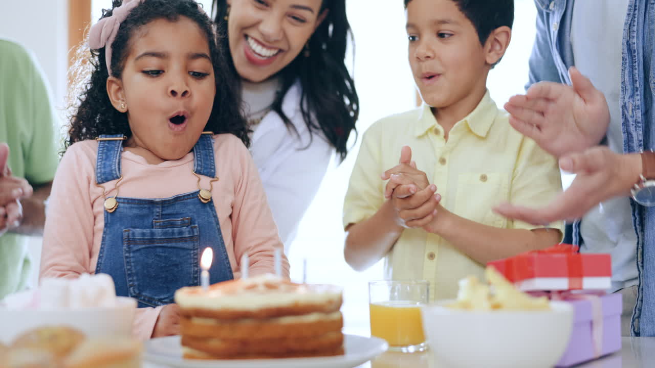 familia feliz, niña pequeña y soplar velas