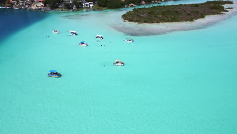 Drone-clip-of-the-7-color-lagoon-in-Bacalar-Mexico-in-4K---Beautiful-Aerial-View-Of-a-boats-in-shallow-Turquoise-Blue-Waters