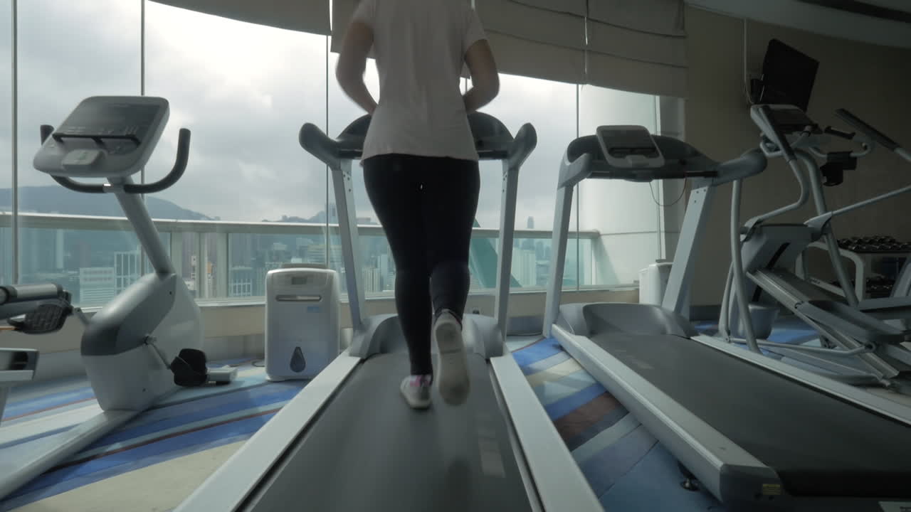 Woman training on treadmill and enjoying cityscape