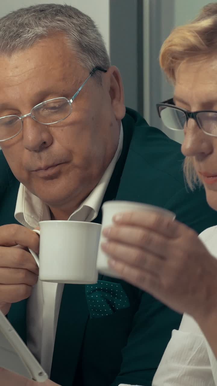 Older adults taking a coffee break while using a smartphone