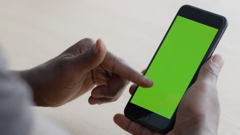 person using a smartphone with a green screen