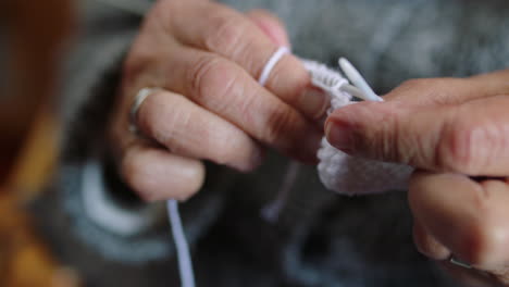 de las manos de la mujer mayor en la jubilación tejer