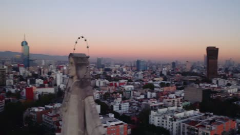 wide establishing drone shot of massive jesus status towering over mexico city at dusk after sunset, featuring parroquia del purism corazon de maria and buildings in the back