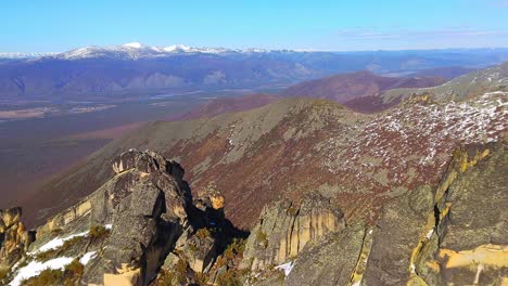 a snowy mountain range with snow-covered ground and towering peaks in the background