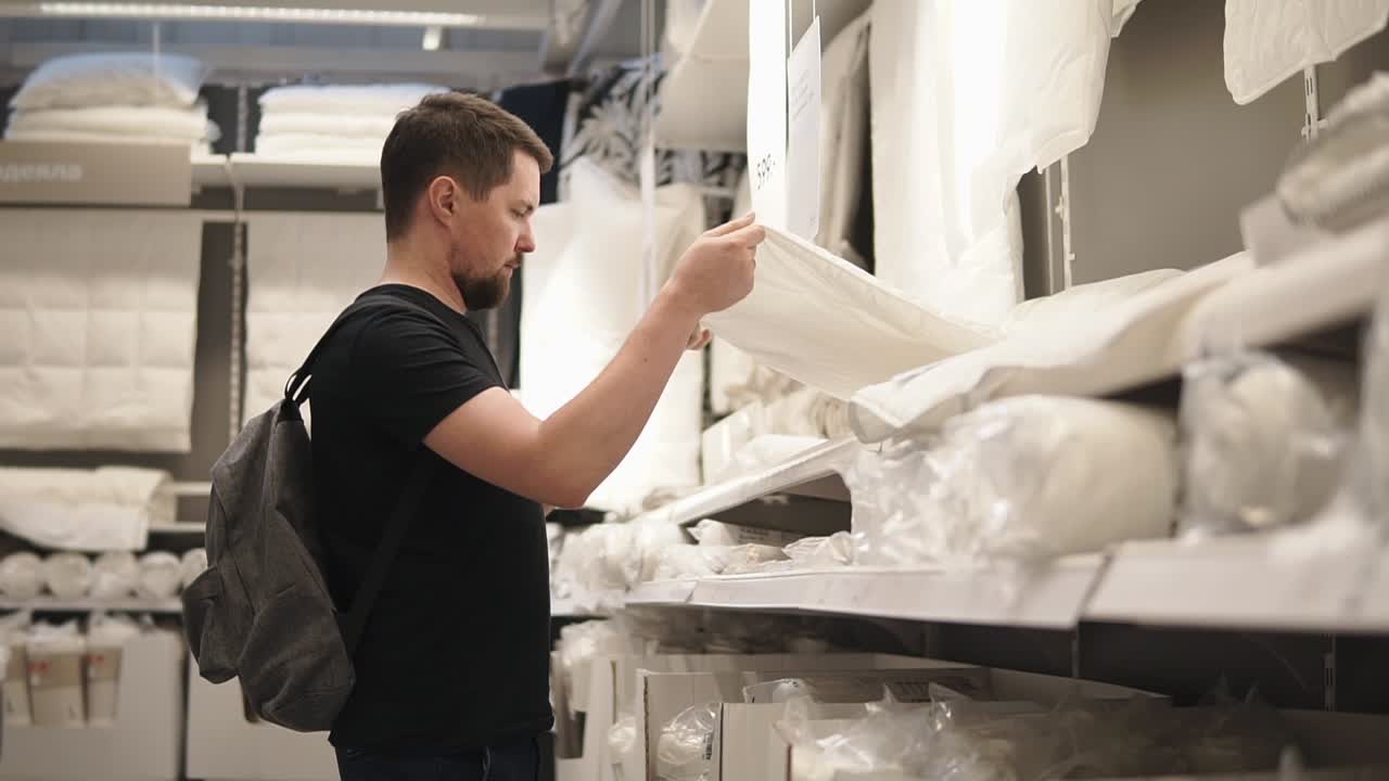 Man shopping for bedding in a home goods store