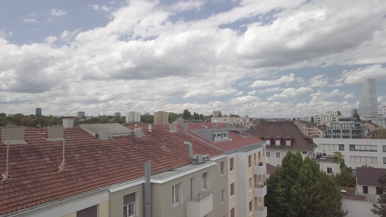 Un drone si alza dal cortile di un condominio svizzero rivelando lo skyline di Basilea e la Torre Roche