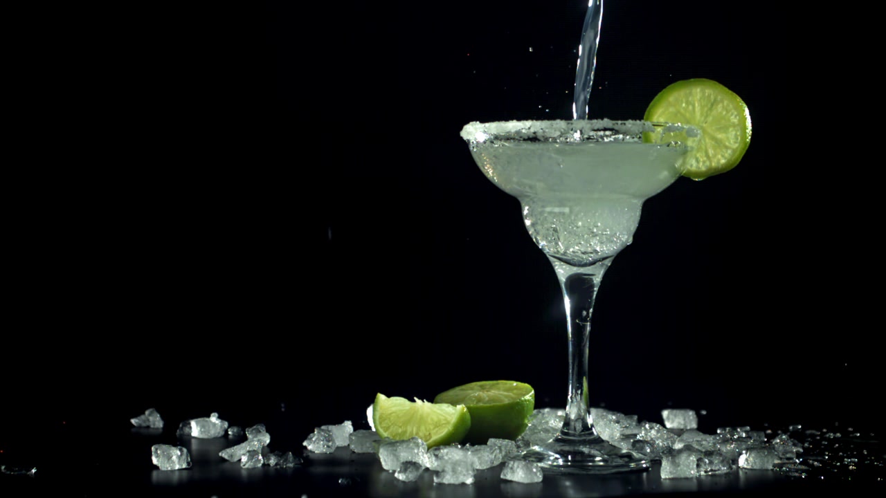 Versare un rinfrescante cocktail Margarita con lime e ghiaccio