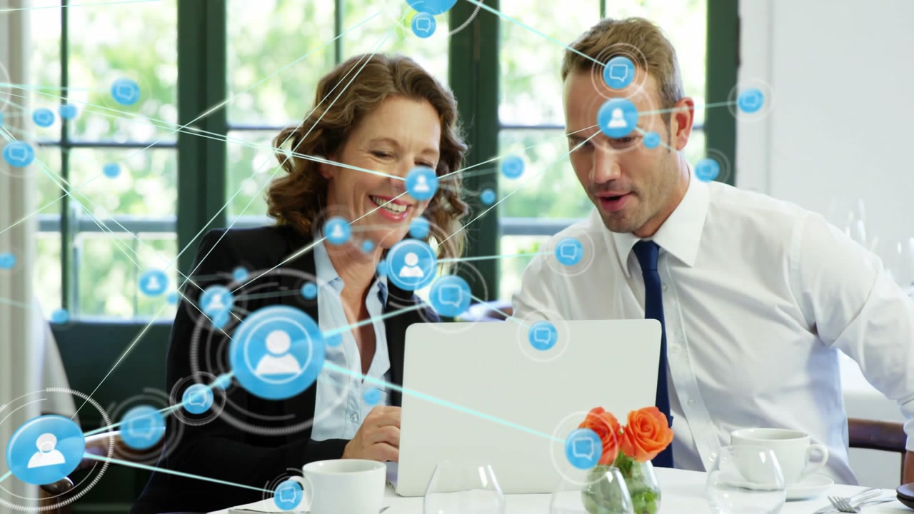 Two business colleagues pointing at laptop, touching screen and expanding blue network for strategy