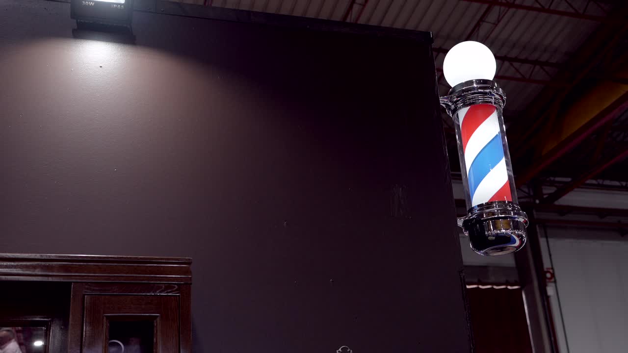 rotating striped barber pole glowing inside contemporary salon