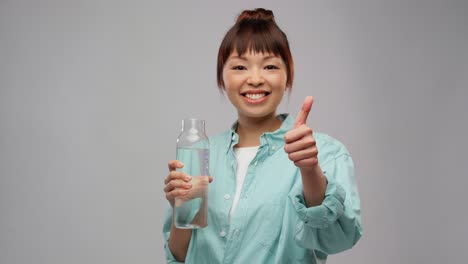 Glückliche-Asiatische-Frau-Hält-Glasflasche-Mit-Wasser.Menschen-Konzept-Porträt-Einer-Glücklich-Lächelnden-Jungen-Asiatischen-Frau-In-Türkisfarbenem-Hemd,-Die-Eine-Wiederverwendbare-Glasflasche-Mit-Wasser-Auf-Grauem-Hintergrund-Hält