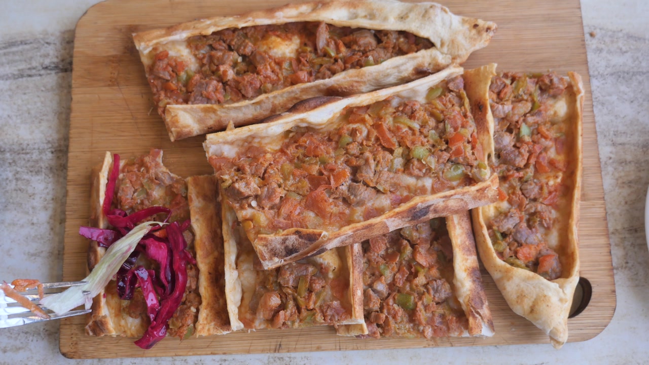 Hand Picking Up a Slice of Delicious Turkish Pide