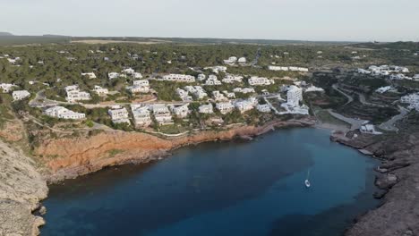 aerial pullback establishes scenic coastal town of cala morell, spain