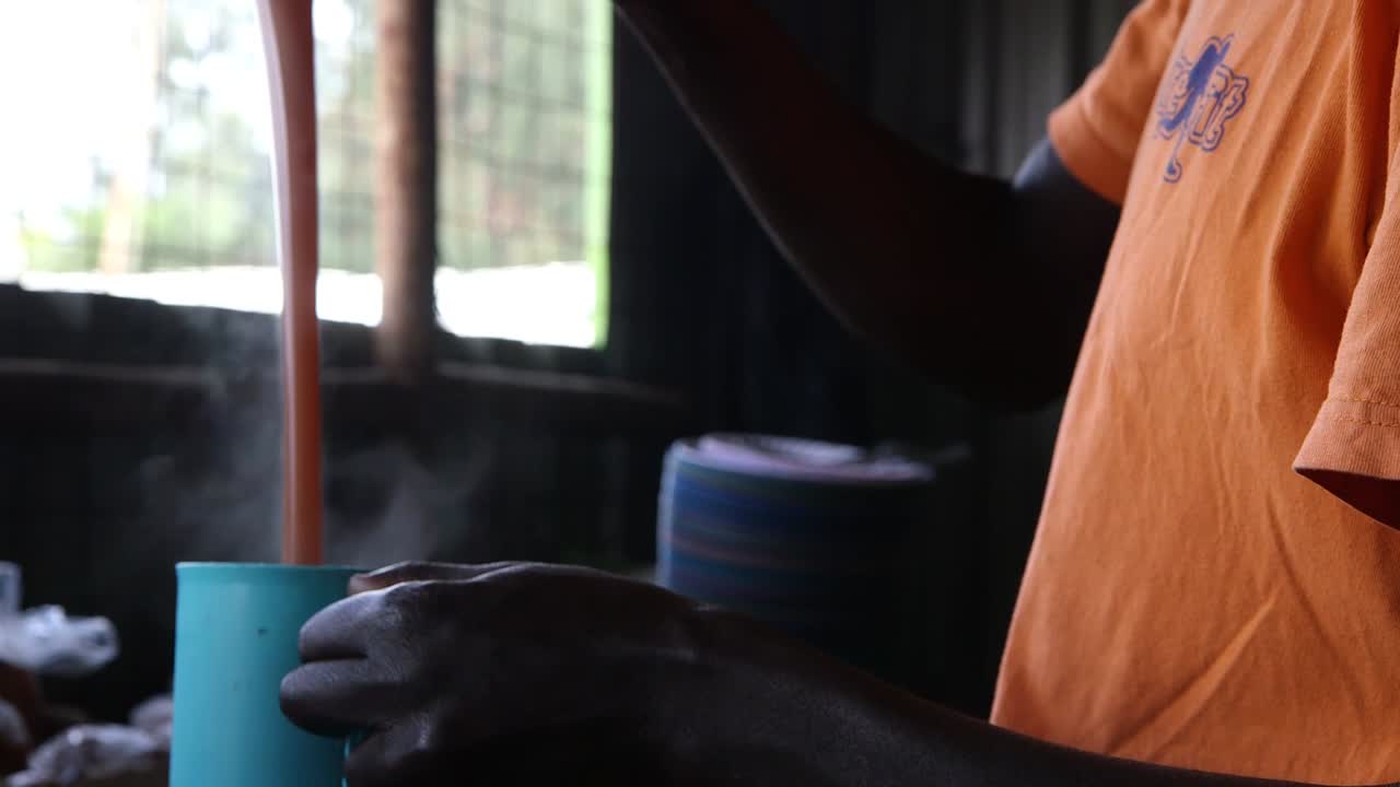 un hombre preparando té para los niños de la escuela en kenia