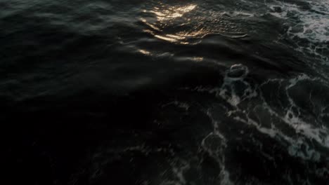 low flyover glistening ocean during sunrise at monterrico on the pacific coast of guatemala