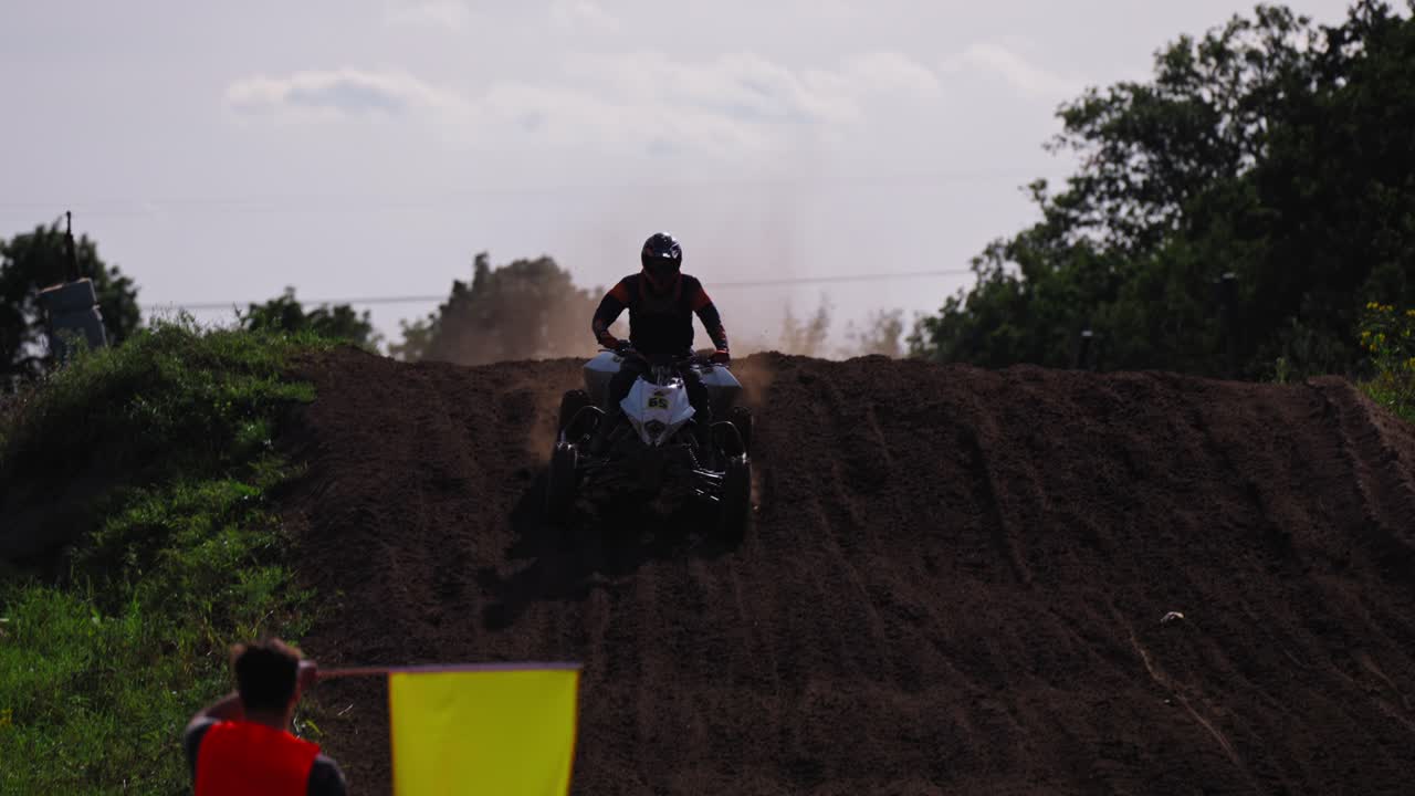 Pilota di quad che scende in discesa in un torneo