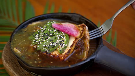 Slow-motion-close-up-of-traditional-mexican-"huevos-divorciados"-with-green-and-red-sauce-topped-with-avocado-and-watermelon-radish-served-on-a-skillet