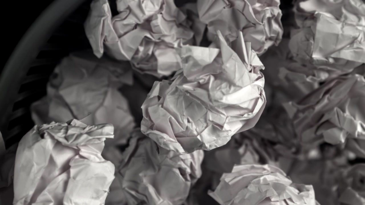 Gros plan sur des boules de papier froissées dans une poubelle