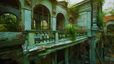 ruined brick building with a balcony overgrown with ivy