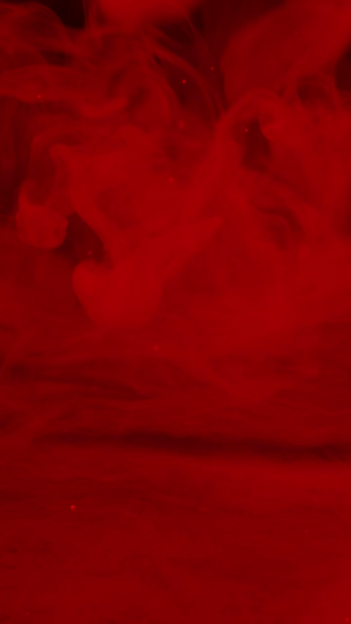 Fumo rosso atmosferico e particelle su sfondo nero
