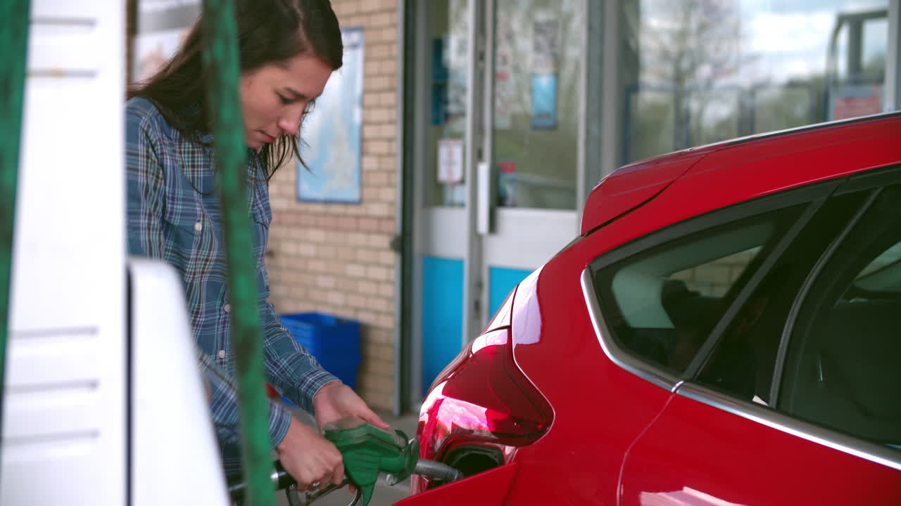 Donna che fa rifornimento a un'auto a un distributore di benzina.