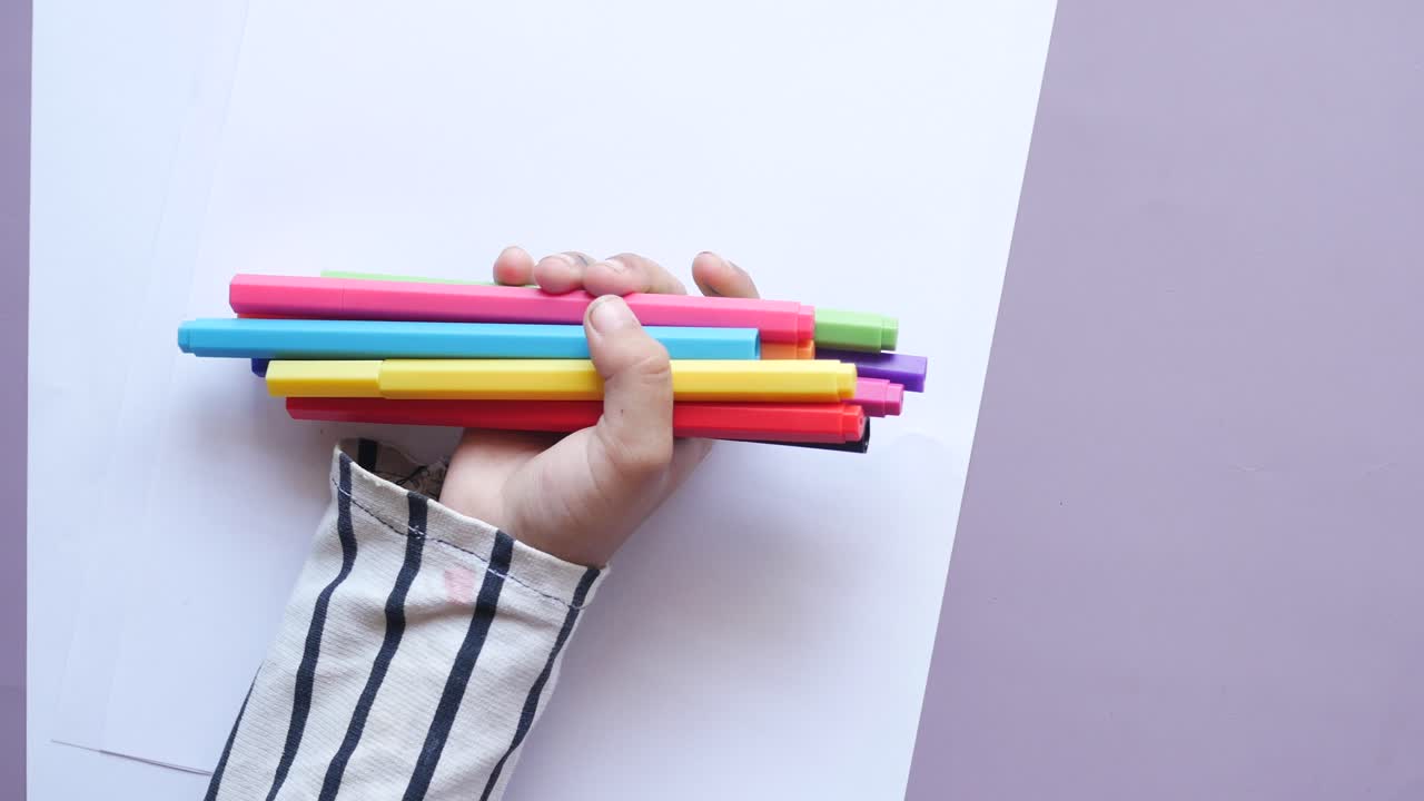 niña sosteniendo muchos lápices