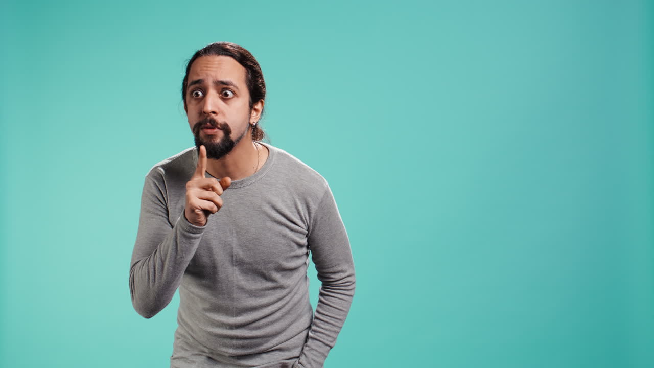 retrato de un hombre haciendo silencio con la mano haciendo gestos, pidiendo silencio