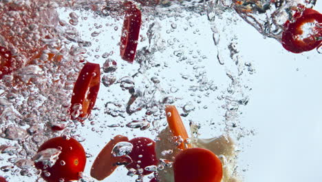 verduras orgánicas de primer plano bajo el agua sobre un fondo blanco. verduras saludables.