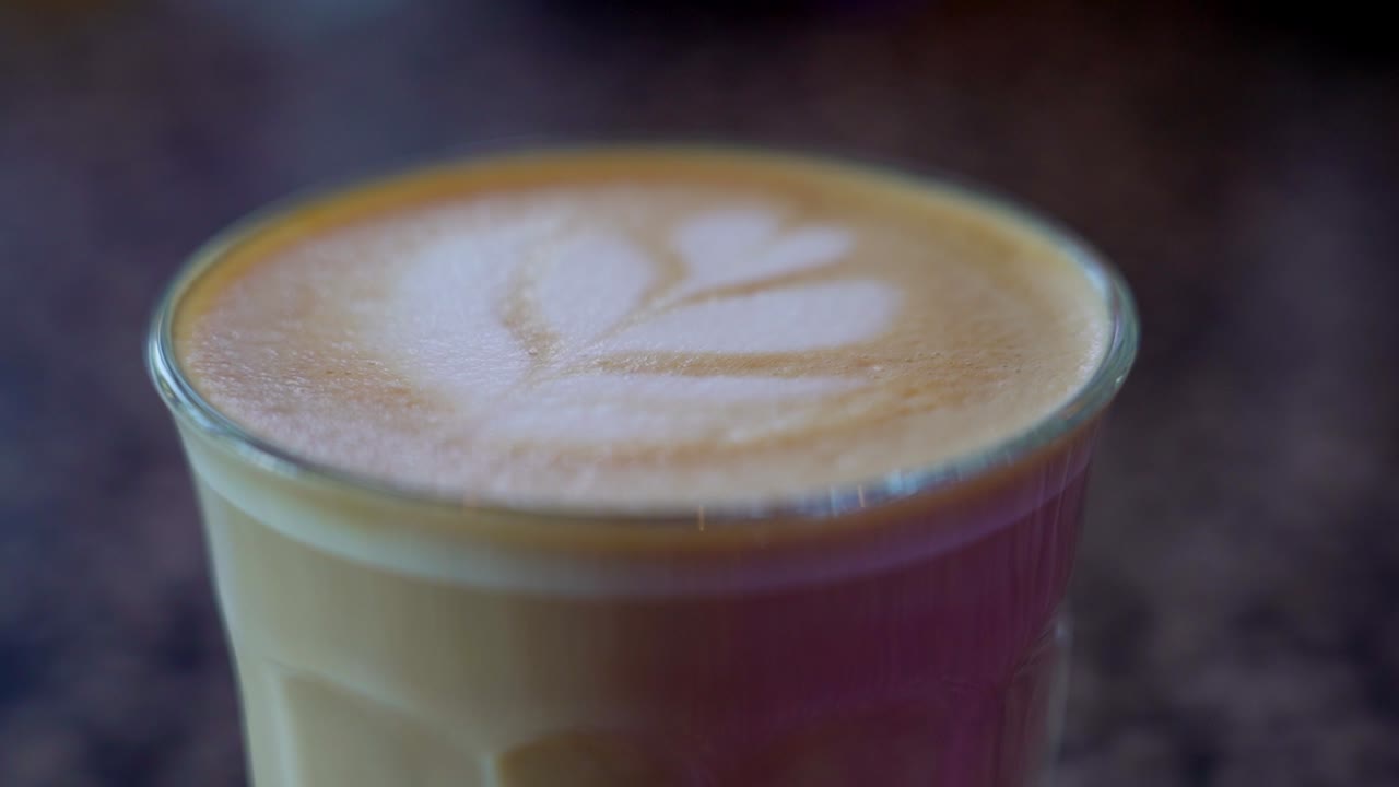 Close-up of latte foam with leaf-shaped art design