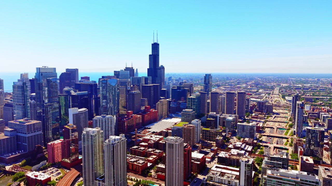 Centro da metrópole com arranha-céus imponentes, Chicago. Vista aérea elevada de um denso centro comercial, linha do horizonte distante e céu azul claro.