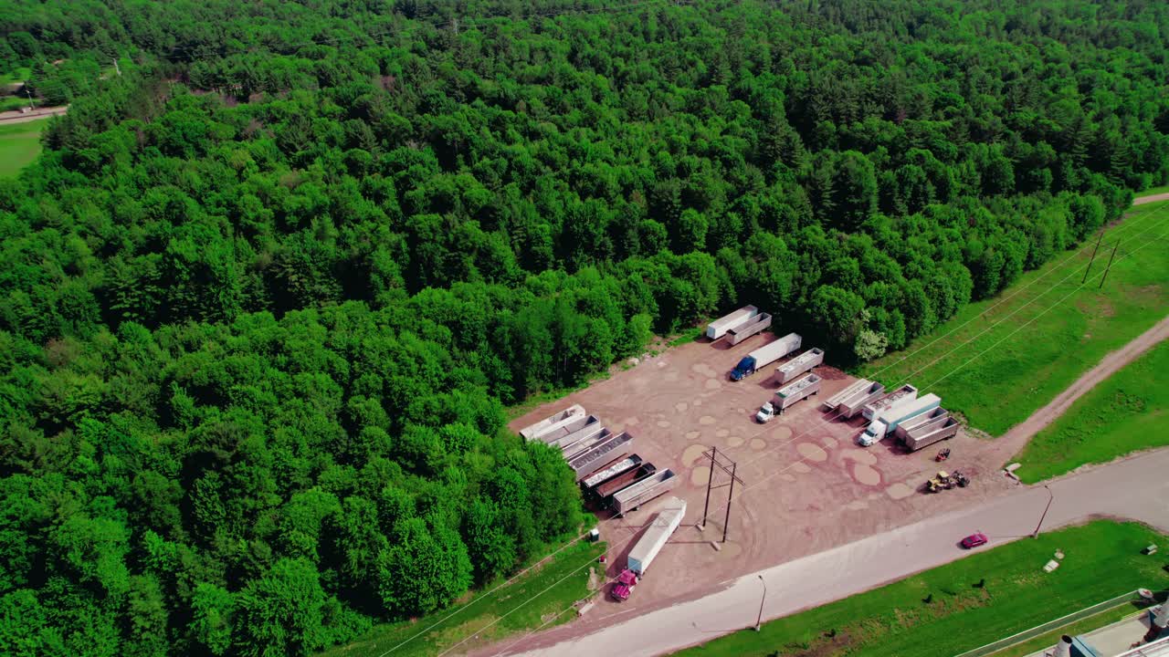 위스콘신 시골의 숲으로 둘러싸인 주차장에서 나가는 하퍼 트레일러와 함께 반 트럭