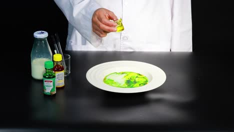 un científico demuestra una reacción de color vibrante en la leche usando colorante alimentario y jabón para platos, creando un efecto visual dinámico