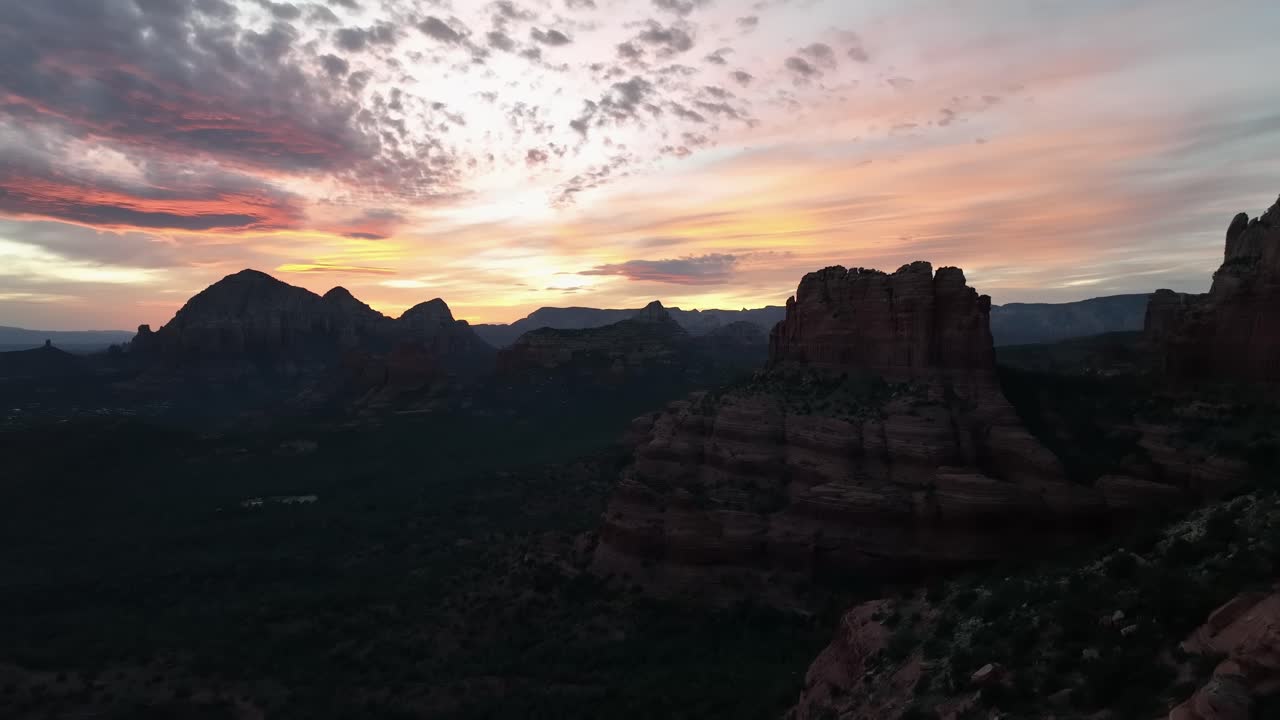 En kvinde står på kanten af Red Cliffs Canyon i Sedona, Arizona ved solnedgang