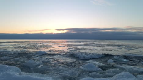 waves crashing on the shore on a winter morning, icebergs ice formations floting on the water