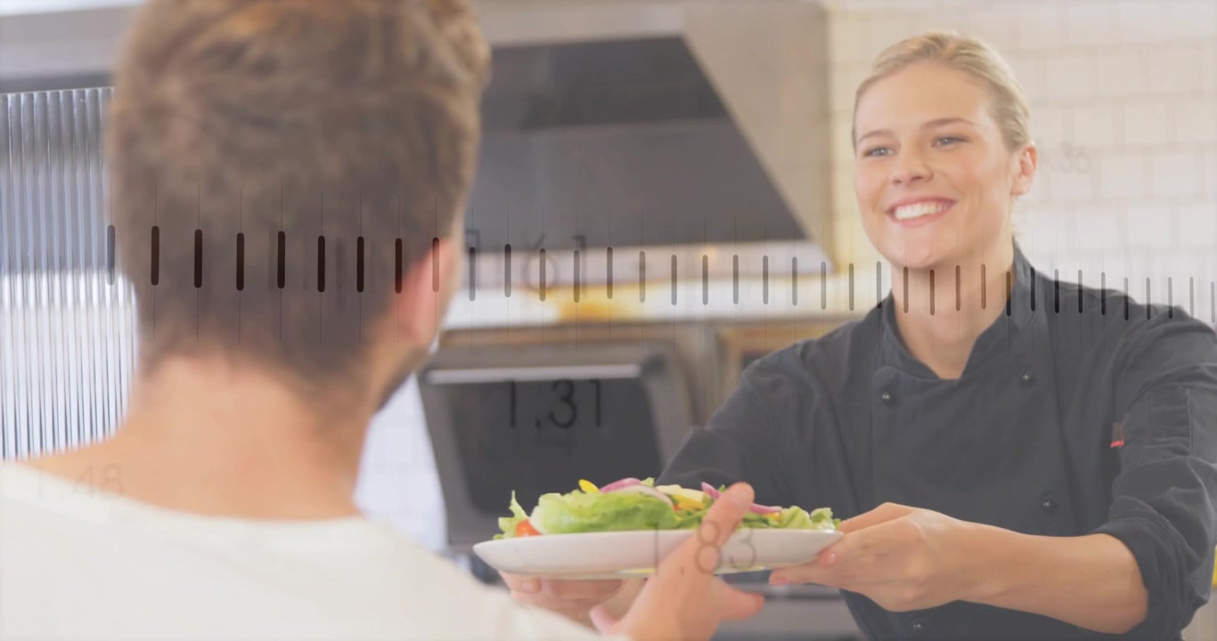 Female chef serving salad across kitchen pass as customer coming and receiving, waveform over pass
