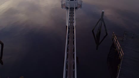 Reveal-shot-of-lighthouse-Oostmahorn-Friesland-during-sunrise,-aerial