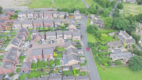 an aerial view captures a peaceful suburban neighbourhood with a mix of detached houses and townhouses neatly lined along curving streets. trees and lawns add green spaces to the residential area